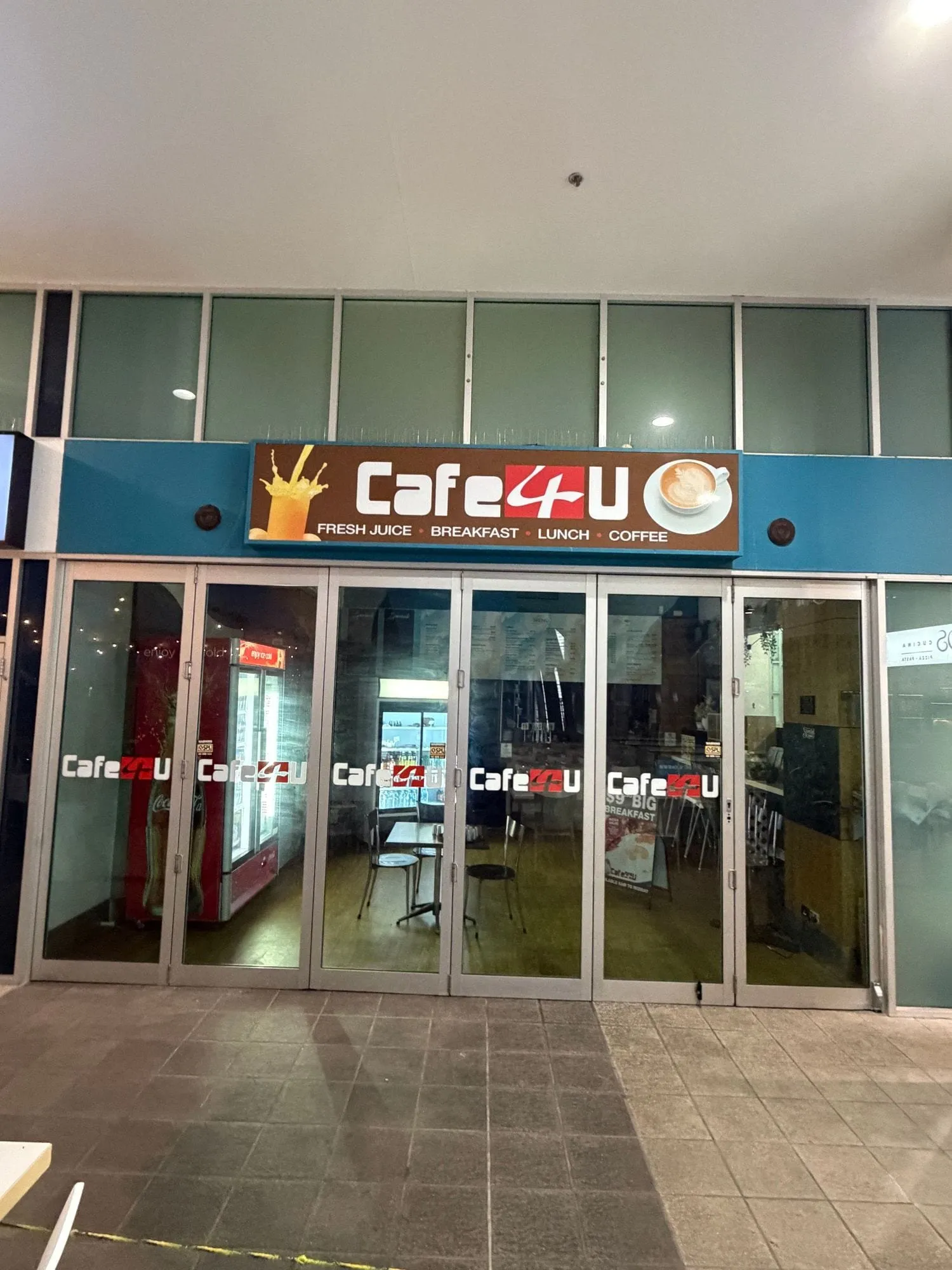 Cafe 4 U at Aqua, a sign reading "Cafe 4 U — fresh juice, breakfast, lunch, coffee" above a glass frontage.