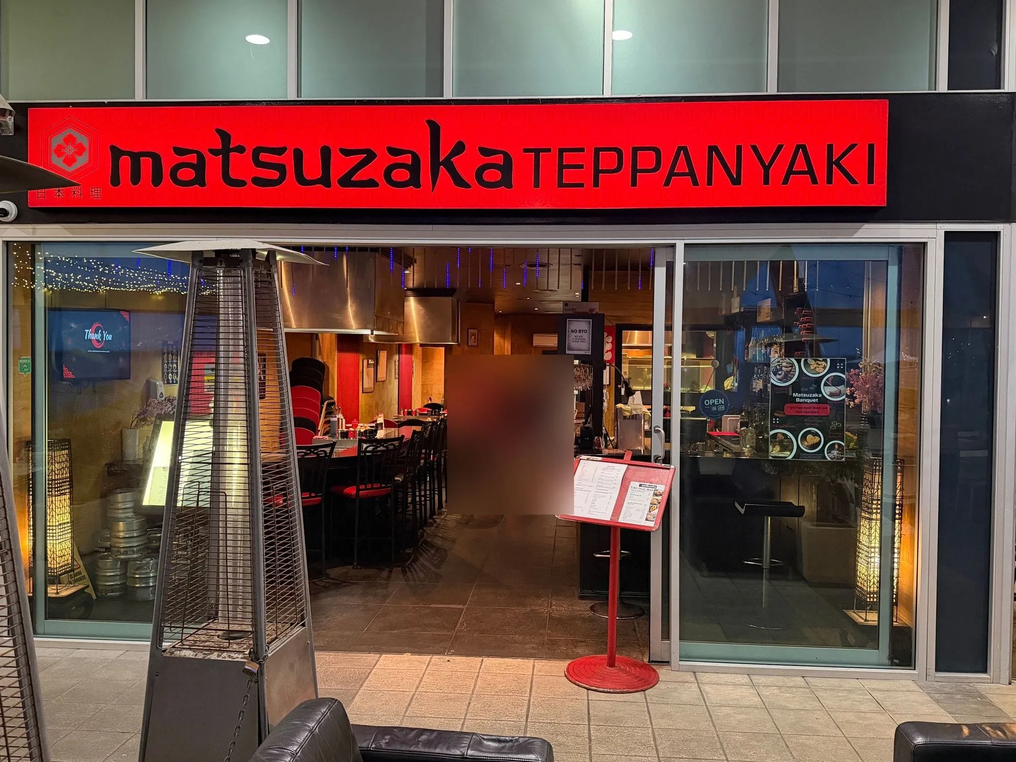 Matsuzaka Teppanyaki at Aqua, a red sign in black lettering above the restaurant frontage and its outdoor seating.